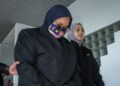 TERTUDUH diiring anggota SPRM selepas dihadapkan ke Mahkamah Majistret, Ayer Keroh, Melaka atas pertuduhan menyalah guna harta dan membuat tuntutan palsu. - UTUSAN/SYAFEEQ AHMAD