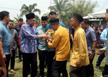 ANWAR Ibrahim bersalaman dengan pengunjung Majlis Santunan Aidilfitri peringkat Parlimen Tambun di Padang RPT Jelapang Baru di Ipoh hari ini. - UTUSAN