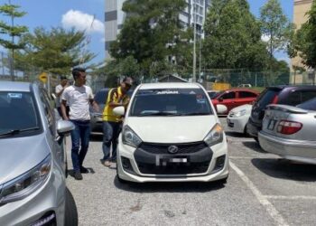 ANGGOTA JPJ menahan seorang prebet sapu yang dikesan menurunkan penumpang di sebuah kolej kediaman pelajar di Nilai, Seremban. - UTUSAN/NOR SHAFAWATI YUP