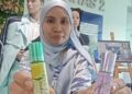 FARAH Nadia Murad  menunjukkan minyak aroma terapi yang dihasilkan oleh pensyarah dan pelajar Kolej Komuniti Batu Gajah di Kampar, Perak, baru-baru ini. – UTUSAN/MEGAT LUTFI MEGAT RAHIM