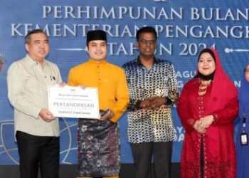 ANTHONY Loke Siew Fook menyampaikan hadiah kepada pemenang tempat pertama kategori Video Kreatif Hari Raya pada Majlis Erat Kasih Madani dan Perhimpunan Bulanan Kementerian Pengangkutan di Putrajaya hari ini. - UTUSAN/FAISOL MUSTAFA