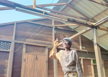 ROSNAH Salleh menunjukkan bumbung rumahnya yang terbangkan angin dalam kejadian ribut tengah malam semalam di Kampung Parit Haji Tahir di Bagan Serai. - UTUSAN/WAT KAMAL ABAS