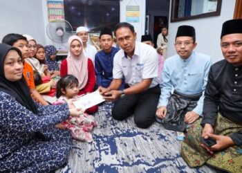 NOR Pahidah Mat Zaman (kiri) menerima sumbangan daripada Mohd. Sabirin Mohd. Sarbini di rumah adik iparnya di Seksyen 24, Shah Alam, Selangor, semalam. – UTUSAN/SADDAM YUSOFF