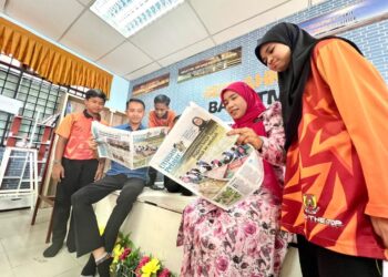 LAKSAMANA Saad (dua dari kiri) dan Fauziah Omar (dua dari kanan) bersama murid-murid tertarik membaca sisipan khas Utusan Pelajar yang diterbitkan setiap Rabu di Sekolah Kebangsaan Putra, Kangar, Perlis, semalam. – UTUSAN/MOHD. HAFIZ ABD. MUTALIB