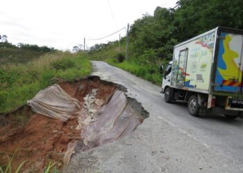 PENDUDUK Orang Asli dan pengguna jalan bergadai nyawa melalui jalan runtuh di Pos Tuel, Gua Musang. - UTUSAN/AIMUNI TUAN LAH