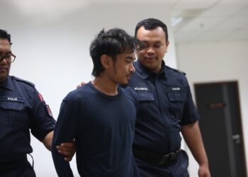 TERTUDUH (tengah) diiringi anggota polis semasa hadir untuk prosiding perbicaraan di Mahkamah Sesyen, Kota Bharu, Kelantan. -UTUSAN/ROSALWANI CHE SOH