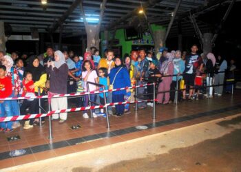 PENGUNJUNG termasuk kanak-kanak beratur panjang untuk menaiki tram dan buggy sempena Melaka Nightlife di Zoo Melaka, Ayer Keroh, Melaka. - UTUSAN/AMRAN MULUP