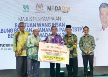 MOHAMAD Sabu (tengah) menyampaikan replika cek bantuan wang ihsan kepada wakil peladang MADA yang terjejas pada Majlis Penyampaian Wang Ihsan Tabung Bencana Tanaman Padi di Ibu Pejabat MADA, Alor Setar.- UTUSAN/ SHAHIR NOORDIN