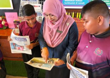 GURU Besar STB, Nor Zaiton Ibrahim (tengah) bersama murid-murid membaca sisipan khas Utusan Pelajar di STB, Arau, Perlis. – UTUSAN