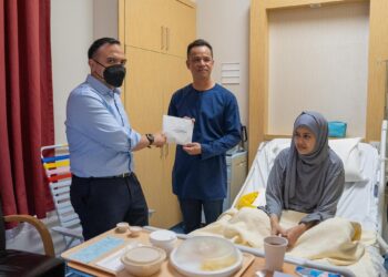 FARHAN Fauzi (kiri) menyampaikan sumbangan kepada Akbar Sahari untuk Noorsuzilawati Noor yang menghidap kanser usus.