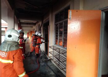 ANGGOTA bomba memadam kebakaran di aras tiga bangunan yang menempatkan bilik asrama SMK Kuala Nerang di Padang Terap.