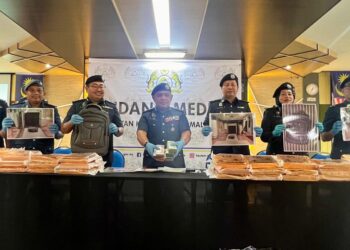 ISMAIL Hashim (empat dari kiri) menunjukkan wang tunai yang dirampas menerusi pemeriksaan di Kompleks Imigresen, Kastam, Kuarantin dan Keselamatan (ICQS) Padang Besar, Perlis, Isnin lalu. -UTUSAN/ASYRAF MUHAMMAD.