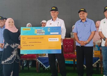 Aminuddin Zulkipli (tengah) menyerahkan replika cek di dalam Majlis Pelancaran Karnival Agro Madani di Pasar Tani Kekal Datin Halimah Johor Bahru 2024 ,di Johor Bahru di sini semalam