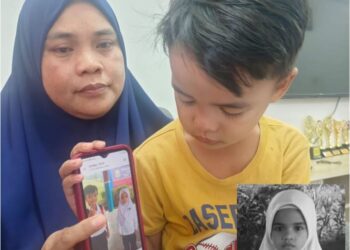 KARMIN Kahil dan Muhammad Afieq Miqhael menunjukkan gambar Nurhafizah (gambar kecil) yang meninggal dunia dilanggar van sekolah di hadapan rumah mereka di Bandar Seri Alam, Pasir Gudang.