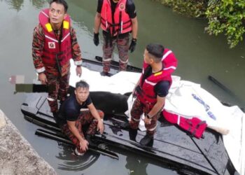 ANGGOTA bomba mengeluarkan tiga mangsa yang lemas selepas kenderaan yang dinaiki mereka terbabas dalam longkang di Danga Bay, Johor Bahru.