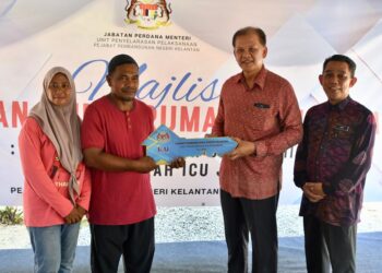 AZMAN Ibrahim (dua dari kanan) menyerahkan replika kunci kepada penerima Projek Bina Baharu Rumah Kasih Ihsan ICU JPM di Kampung Tikat, Pantai Cahaya Bulan (PCB), Kota Bharu, Kelantan.UTUSAN/ROSMIZAN RESDI