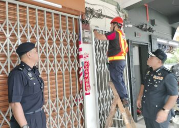 BAHRIN Mohd. Noh (kanan) menyaksikan kerja-kerja pemotongan bekalan elektrik oleh petugas Tenaga Nasional Berhad (TNB) ke atas sebuah premis di Jalan Pala, Taman Suria, Kluang.