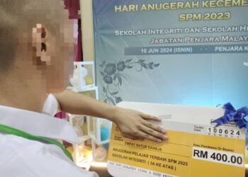AIMAN menunjukkan imbuhan diterimanya pada Majlis Anugerah Kecemerlangan Sekolah Integriti dan Sekolah Henry Gurney di Penjara Kluang.
