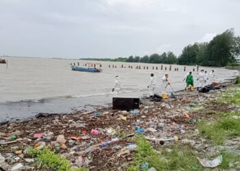 KONTRAKTOR  melakukan kerja pembersihan susulan tumpahan minyak di pesisir pantai Sungai Rengit hingga Teluk Ramunia, Pengerang.