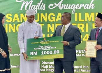 MUHAMMAD Sanusi Md. Nor menyampaikan replika cek kepada pelajar cemerlang SPM, Muhammad Faezzuddin Mohd Arief yang memperoleh 11A pada Majlis Anugerah Sanjungan Ilmu Peringkat Negeri di Wisma Darul Aman, Alor Setar.