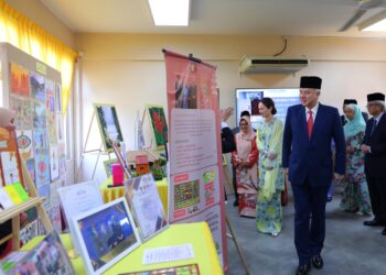 SULTAN Nazrin Muizzuddin Shah  dan Tuanku Zara Salim melawat pameran pada perasmian SBPI Gopeng hari ini. - UTUSAN