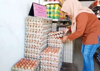 SITI Aisyah Yusof membeli telur di sebuah kedai runcit di Kampung Bukit Besar, Kuala Terengganu, semalam. – UTUSAN/TENGKU DANISH BAHRI TENGKU YUSOFF