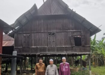 MUHAMAD Jamil Ismail (tengah) bersama waris yang menjaga sebuah rumah lama berusia 100 tahun di Kampung Teluk Sareh, Pasir Salak. - UTUSAN/AIN SAFRE BIDIN