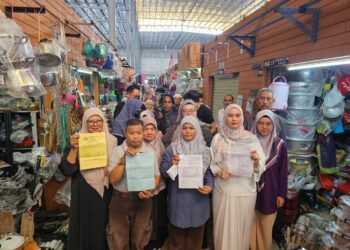 BEBERAPA peniaga menunjukkan surat tawaran premis baharu Pasar Kedai Payang di Kuala Terengganu, semalam. – UTUSAN/ZAID MOHD. NOOR
