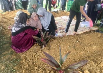 QAISARA Damia Ridwan (tengah) ditenangkan oleh ahli keluarga selepas tidak dapat menanggung kesedihan semasa pengebumian jenazah kedua ibu bapanya maut kemalangan di Tanah Perkuburan Islam Tunjong, Kota Bharu, Kelantan-UTUSAN/ROSMIZAN RESDI.
