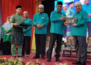 TAKIYUDDIN Hassan (dua dari kanan) menyampaikan 'photobook' kepada Ahmad Yahaya (kanan) sebagai gimik perasmian Mesyuarat Agung Tahunan Pas Kawasan Kota Bharu Kali Ke-57 di Dewan Perniagaan Cina Kelantan di Kota Bharu, Kelantan hari ini. UTUSAN/MUSTAQIM MOHAMED