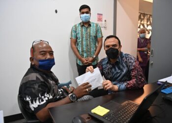Bob (kiri) yang merupakan antara aktivis awal era Reformasi menerima sumbangan daripada Farhan (kanan) baru-baru ini.-FACEBOOK ANWAR