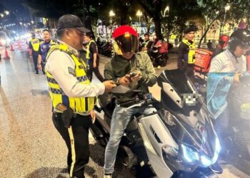 ANGGOTA Trafik melakukan pemeriksaan terhadap penunggang motosikal dalam Op Hormat Undang-Undang Kontinjen Kuala Lumpur malam tadi.