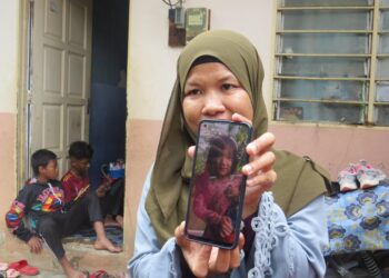 NOREMELY Angah menunjukkan gambar anaknya, Syamely Nur Aleh Qarni Sham di Kampung Setawar, Rancangan Pengumpulan Semula (RPS) Kuala Betis, Gua Musang, Kelantan hari ini-UTUSAN/AIMUNI TUAN LAH.