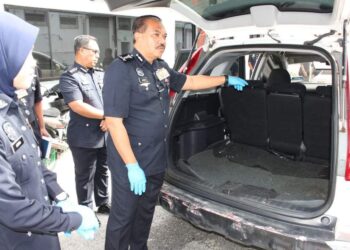 HAMZAH Ahmad (kanan) menunjukkan bahagian kereta yang dijadikan tempat menyimpan dadah jenis ganja dalam satu sidang akhbar di IPK Pulau Pinang, hari ini