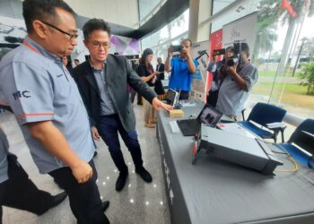 Chang Lih Kang (kiri) mendengar penerangan Pengurus Jualan Tektronik Instrumen Malaysia Sdn Bhd, Daniel Choong berkaitan peralatan elektronik selepas majlis Peluncuran ITIC di KHTP, Kulim hari ini.