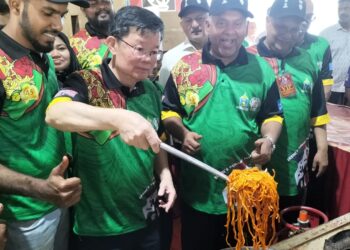CHOW Kon Yeow (dua dari kiri) turut menunjukkan aksi menggoreng mi sotong di Padang Kota Lama, Georgetown, Pulau Pinang.
