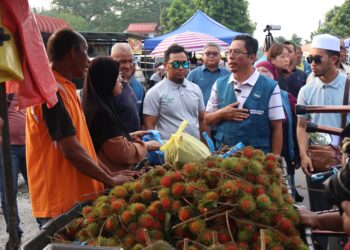 ABIDIN Ismail (dua dari kanan) bertegur sapa dengan peniaga di pasar malam Puteri Gunong, Simpang Ampat, Nibong Tebal, ketika berkempen di kawasan itu.