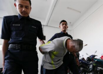 TERTUDUH (tengah) semasa untuk prosiding perbicaraan di Makhamah Majistret, Kota Bharu, Kelantan hari ini-UTUSAN/ROSALWANI CHE SOH.