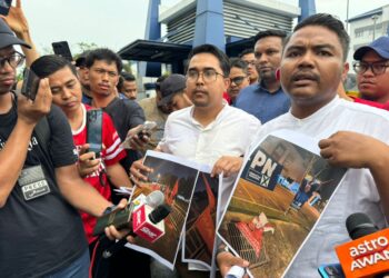 MUHAMMAD Fadzli (kanan) menunjukkan bahan kempen PH yang dirosakkan di IPD Seberang Perai Selatan di Jawi, Nibong Tebal, hari ini