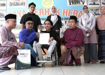 MOHD. ZAWAWI Zainal Abidin (duduk, dua dari) hadir menyampaikan surat tawaran pengajian kepada Muhammad Adib Nadhir Mohd. Zaharizan (tengah) di Sekolah Menengah Kebangsaan (SMK) Chengal Lempong, Kuantan, hari ini. - UTUSAN/DIANA SURYA ABD. WAHAB