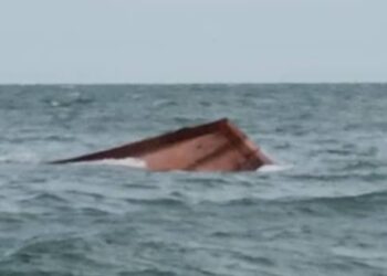 KEADAAN Bot nelayan yang karam di perairan Tanjung Segenting di Batu Pahat pagi tadi.