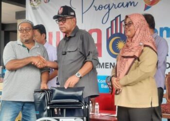 SAIFUDDIN Nasution Ismail (tengah) menyampaikan sumbangan kerusi roda kepada seorang penerima di majlis perasmian Program Jiwa Komuniti Madani Peringkat Parlimen Kulim Bandar Baharu. - UTUSAN/AZAHAR HASHIM