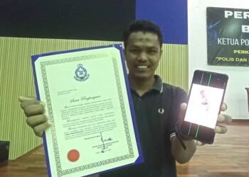 ABDULLAH Abdul Talib menunjukkan surat penghargaan yang diterimanya pada Majlis Perhimpunan Bulanan Ketua Polis Daerah Muallim di Tanjung Malim hari ini. - UTUSAN