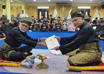 ABDUL Razak Mohd. Yassin (kiri) menerima dokumen pemberitahuan daripada Zaharudin (kanan) pada Istiadat Pemakluman Kekosongan Pesaka Undang Luak Rembau ke-22 di Rembau hari ini.-UTUSAN/NAZARUDIN SHAHARI.