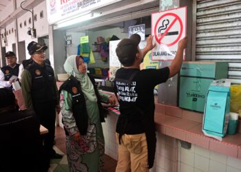 KASEMANI Embong, (dua, kanan) melihat  seorang pemilik premis menampal
poster 'Dilarang Merokok' pada Operasi Cakna Undang-Undang Kesihatan Awam Siri 3/2024 di Pantai Batu Buruk, Kuala Terengganu, hari ini. - UTUSAN/PUQTRA HAIRRY ROSLI