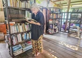 ROHANI Abdullah membaca buku yang terdapat di Perpustakaan Rohani di Pulau Duyung, Kuala Terengganu. - UTUSAN/ZAID MOHD. NOOR