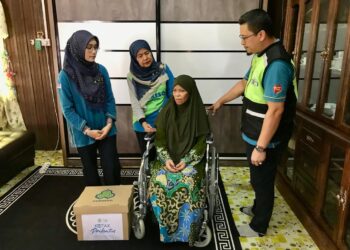 NORA Yaacob (tengah) bersama pesakit kanser payu dara dan tulang, Rosliza Muhamad Amin di Kampung Manek Urai, Kuala Krai semalam. – UTUSAN/ ROSLIZA MOHAMED