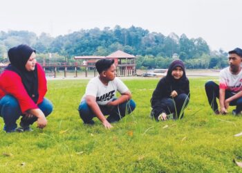 PENGUNJUNG teruja melihat dasar Tasik Bukit Merah di Bagan Serai, Perak yang ditumbuhi rumput berikutan air di tasik itu kering sejak tiga bulan lalu. – UTUSAN/WAT KAMAL ABAS