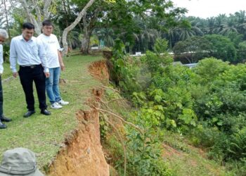 TAN CHONG (tengah) meninjau hakisan cerun SMK Bekok yang menjadi kebimbangan warga sekolah sejak tahun lalu.