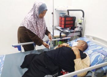 NORAFIZA Abd. Rahman menguruskan keperluan Mazihan Mahat yang terlantar selepas kedua-dua kakinya dipotong di Taman Pinggiran Senawang, Seremban, Negeri Sembilan. – MINGGUAN/NUR SHARIEZA ISMAIL